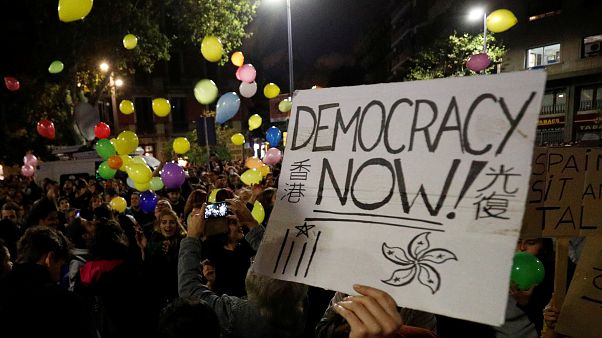 A person holds a placard as pro-independence activists throw balloons during a protest outside the Spanish government delegation offices in Barcelona, Spain October 21, 2019. A person holds a placard as pro-independence activists throw balloons during a protest outside the Spanish government delegation offices in Barcelona, Spain October 21, 2019.