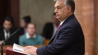 Hungarian opposition MP holds 'lies' sign during Orban's parliament speech