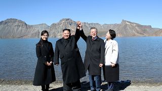الرئيس الكوري الجنوبي مون جاي إن والزعيم الكوري الشمالي كيم جونغ أون رفقة زوجتيهما، يلتقطان صوراً بجانب بحيرة هيفن ماونت في كوريا الشمالية