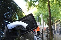 An electric car charges at a roadside charging point