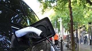 An electric car charges at a roadside charging point