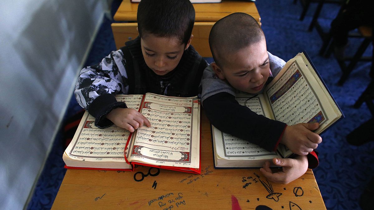 Niños refugiados uigures leen el Corán donde se encuentran en un complejo cerrado en la ciudad central de Kayseri, Turquía, el 11 de febrero de 2015.