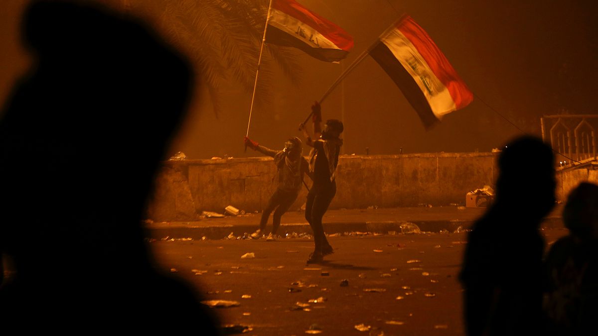 متظاهران يرفعان علم العراق خلال احتجاجات وسط بغداد - 2019/10/26