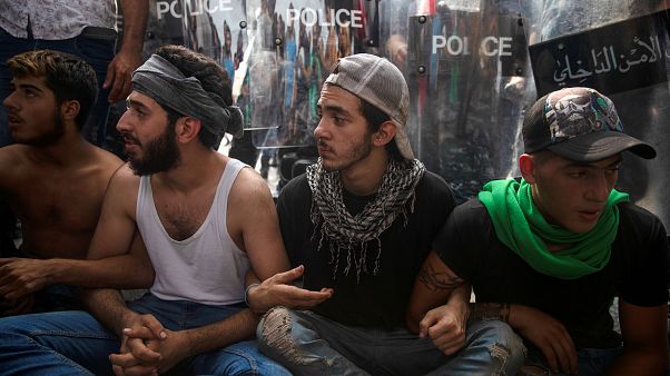 محتجون يجلسون أمام طوق امني وسط بيروت، إثر محاولة الشرطة فتح طريق قطعها المتظاهرون - 2019/10/25 محتجون يجلسون أمام طوق امني وسط بيروت، إثر محاولة الشرطة فتح طريق قطعها المتظاهرون - 2019/10/25