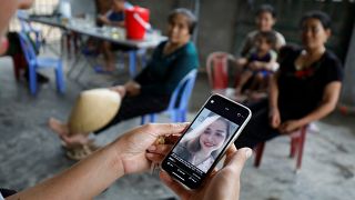 A relative looks at an image of Anna Bui Thi Nhung, a Vietnamese suspected victim in a truck container in UK, at her home in Nghe An province