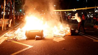 A Catalan pro-independence demonstrator throws a fence into a fire during a protest against police action in Barcelona, Spain, October 26, 2019. 