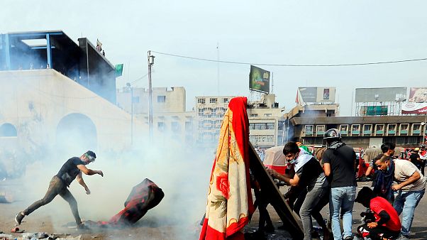 Protesters in Baghdad attempt to throw tear gas canisters back at security services Protesters in Baghdad attempt to throw tear gas canisters back at security services