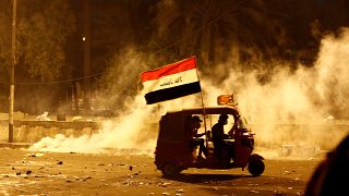 Bağdat'ta göstericiler güvenlik güçlerinin kullandığı biber gazından bir araç ile kaçmaya çalışırken