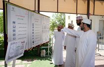 ناخبون بمدينة السمايل شمالي شرقي سلطنة عمان ينظرون إلى قوائم المرشحين لانتخابات مجلس الشورى. 27/10/2019