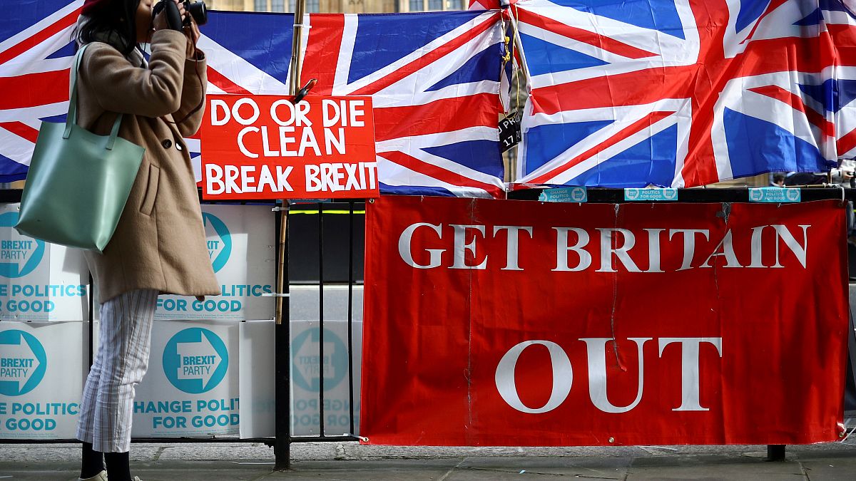 Una mujer toma fotos al lado de las pancartas pro-Brexit frente a las Cámaras del Parlamento en Londres, Reino Unido, el 28 de octubre de 2019. 