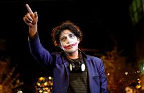 معترضی با گریم جوکر در بولیوی با پلیس صحبت می‌کند