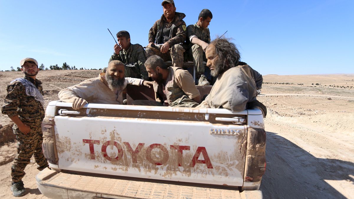FILE PHOTO: Three men that Democratic Forces of Syria fighters claimed were jihadist fighters sit on a pick-up truck while being held as prisoners, Syria, February 18, 2016 