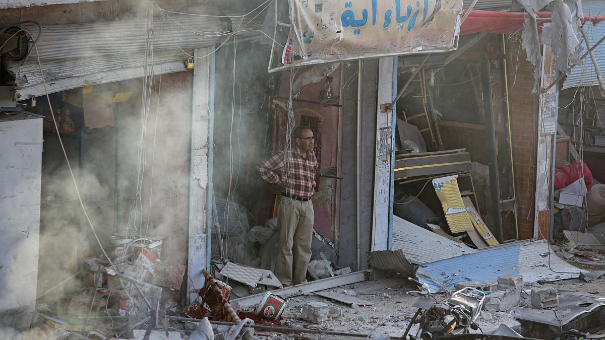 مواطن سوري ينظر إلى السيارة المففخة التي انفجرت في سوق مدينة تل أبيض شمال سوريا. السبت 02/11/2019