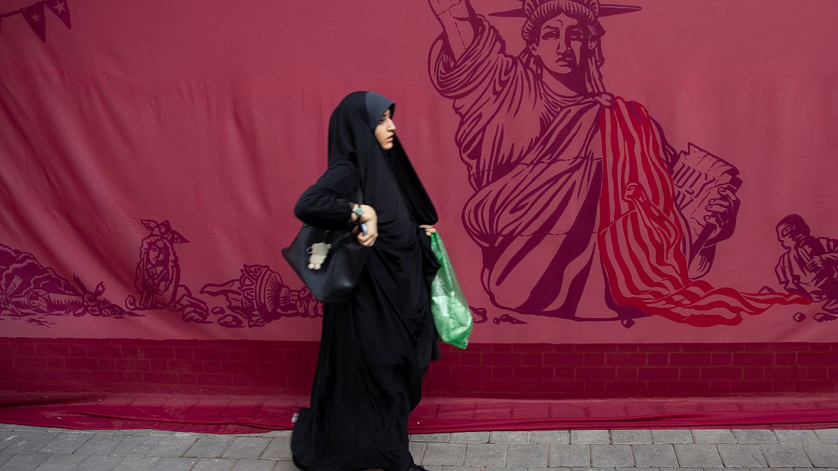 Tahran'da eski ABD Büyükelçiliği binası önünden geçen bir kadın