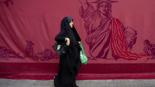 Tahran'da eski ABD Büyükelçiliği binası önünden geçen bir kadın Tahran'da eski ABD Büyükelçiliği binası önünden geçen bir kadın