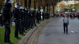 Riot police officers line up as Catalan separatist protesters gather outside the Palau de Congressos de Catalunya