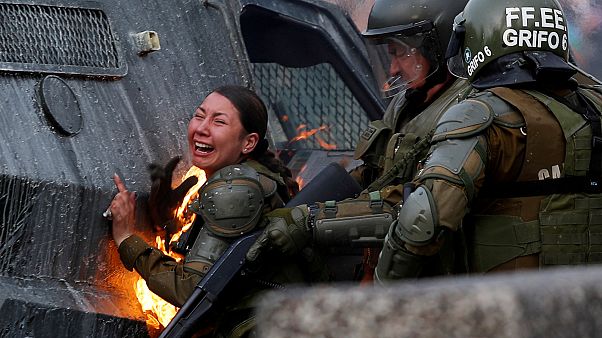 Una mujer policía en llamas durante los disturbios del lunes en Santiago Una mujer policía en llamas durante los disturbios del lunes en Santiago