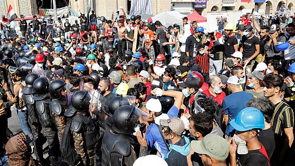 متظاهرون عراقيون يتشاجرون مع الشرطة في العاصمة بغداد متظاهرون عراقيون يتشاجرون مع الشرطة في العاصمة بغداد