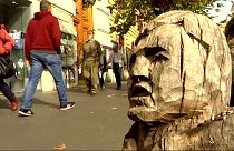 Szobrokat farag utcai fatuskókba egy római férfi