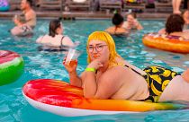 Woman on a lilo at a pool party 