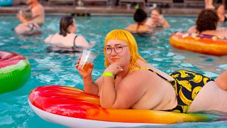 Woman on a lilo at a pool party 