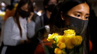 A woman pays tribute with flowers to Chow Tsz-lok, 22, a university student who died after he fell during a protest in Hong Kong, China, November 8, 2019.