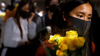 A woman pays tribute with flowers to Chow Tsz-lok, 22, a university student who died after he fell during a protest in Hong Kong, China, November 8, 2019. 