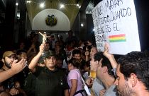 A police officer holds a crucifix as opponents to Bolivia's President Evo Morales cheer in Santa Cruz de la Sierra, Bolivia, November 8, 2019. 