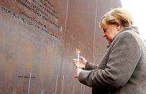 German Chancellor Angela Merkel lights a candle at the memorial of the divided city and the victims of communist tyranny