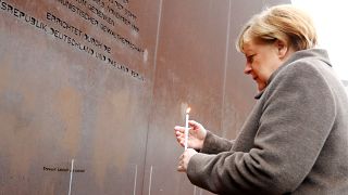 German Chancellor Angela Merkel lights a candle at the memorial of the divided city and the victims of communist tyranny