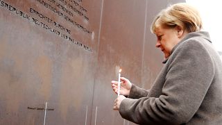 German Chancellor Angela Merkel lights a candle at the memorial of the divided city and the victims of communist tyranny 