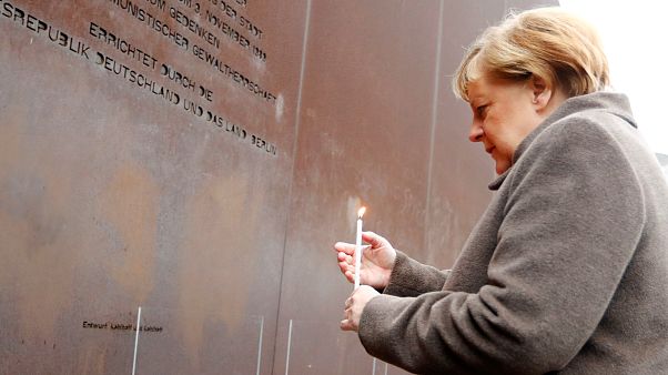 German Chancellor Angela Merkel lights a candle at the memorial of the divided city and the victims of communist tyranny German Chancellor Angela Merkel lights a candle at the memorial of the divided city and the victims of communist tyranny