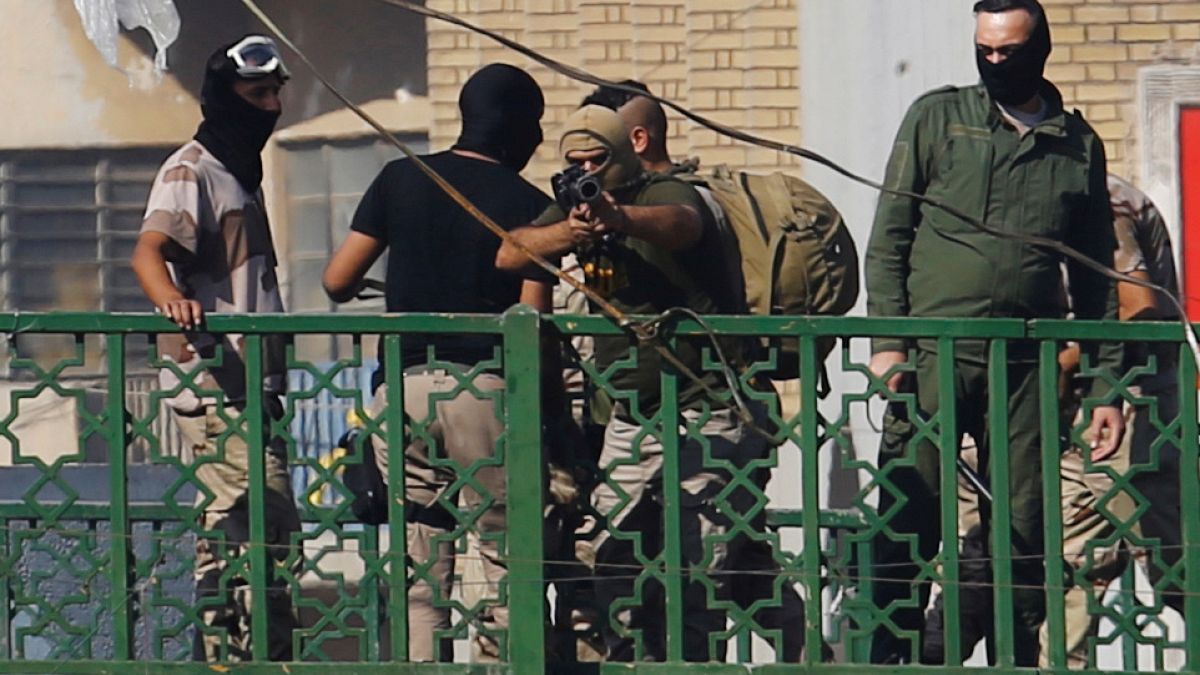 أحد أفراد قوات الأمن العراقية يوجه سلاحه نحو المتظاهرين في بغداد - 2019/11/09 -