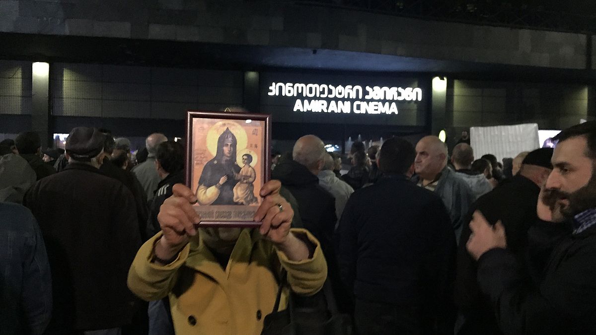 A woman holds a religious icon as she protests against the screening of "And Then We Danced", a Georgian movie about gay love in Tbilisi, Georgia