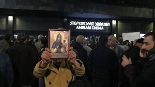 A woman holds a religious icon as she protests against the screening of "And Then We Danced", a Georgian movie about gay love in Tbilisi, Georgia