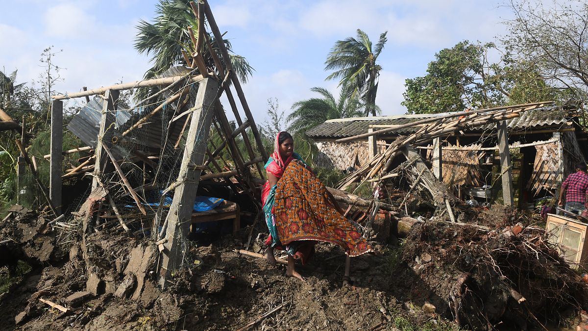 A woman cleans her house damaged by Cyclone Bulbul in Bakkhali on November 10, 2019