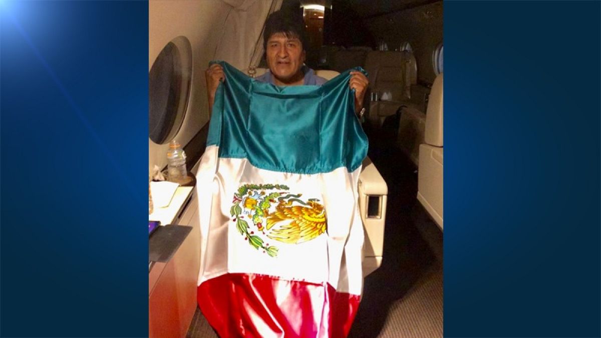 Former Bolivian President Evo Morales holds a Mexican flag onboard a Mexican government's aircraft in an unidentified location  November 11, 2019