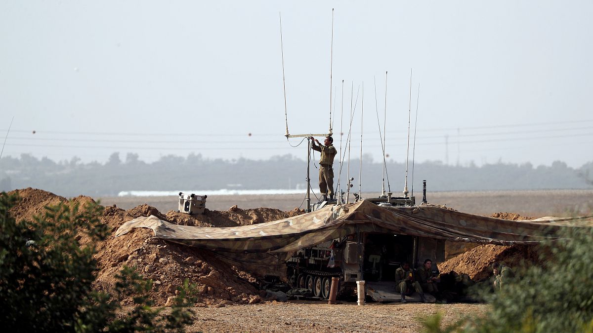 soldato israeliano al confine con gaya a sud d'Israele mentre regola il sistema di comunicazione