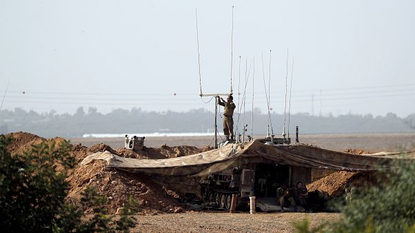 soldato israeliano al confine con gaya a sud d'Israele mentre regola il sistema di comunicazione soldato israeliano al confine con gaya a sud d'Israele mentre regola il sistema di comunicazione