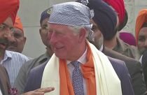 Prince Charles flips Indian flatbread at community kitchen in New Delhi