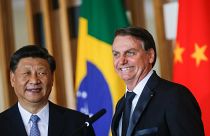 Brazil's President Jair Bolsonaro reacts next to China's President Xi Jinping as they deliver a joint statement after a bilateral meeting during the BRICS summit in Brasilia