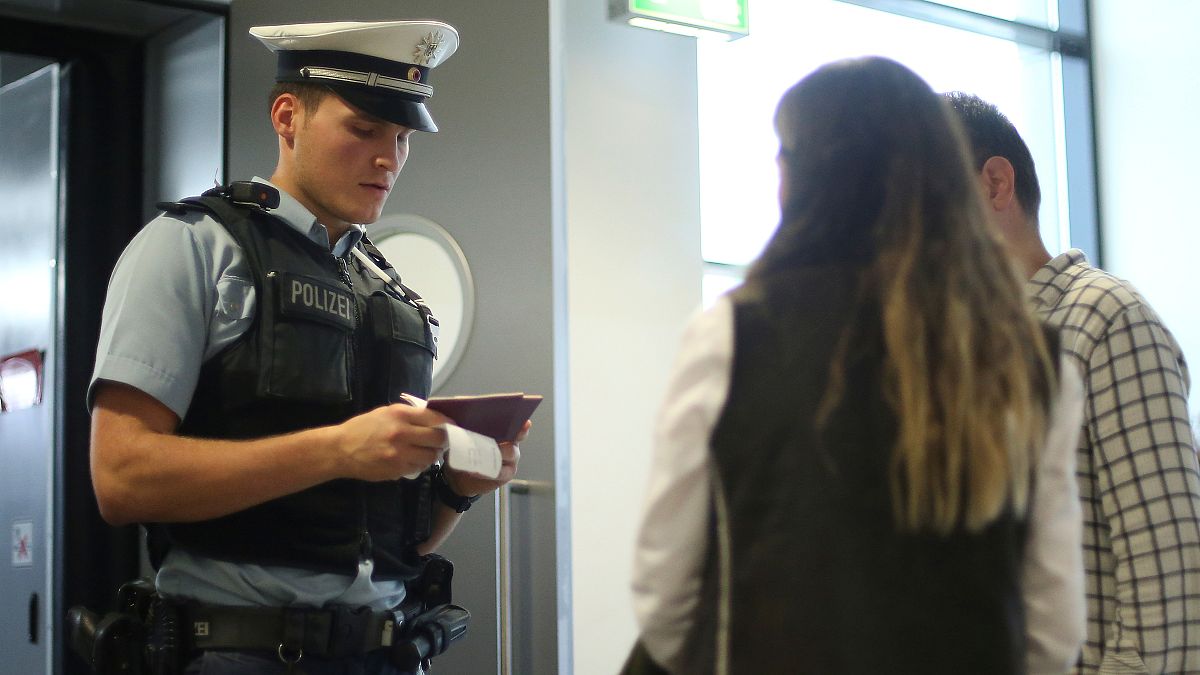 ضابط شرطة يتحقق من وثائق ركاب الرحلات الجوية في مطار فرانكفورت