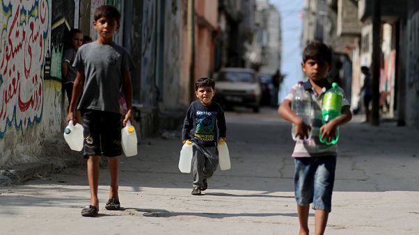 فتيان فلسطينيون يحملون زجاجات مياه أثناء سيرهم في مخيم الشاطئ في مدينة غزة فتيان فلسطينيون يحملون زجاجات مياه أثناء سيرهم في مخيم الشاطئ في مدينة غزة