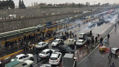 People stop their cars in a highway to show their protest for increased gas price in Tehran, Iran