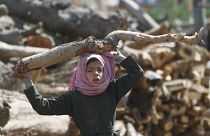 فتاة تحمل الحطب في أحد الأسواق في ظل نقص الوقود وغاز الطهي في صنعاء باليمن