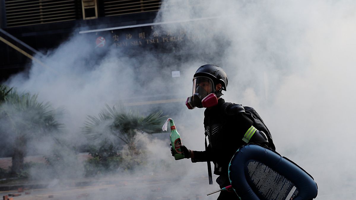 Ein Demonstrant schützt sich mit Gasmaske vor dem Rauch