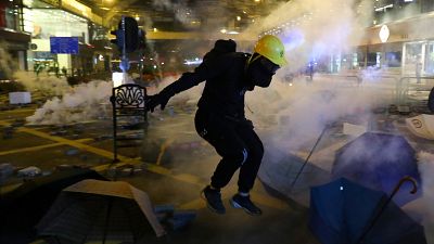 A protester runs from tear gas during clashes with riot police at Tsim Sha Tsui, in Hong Kong, China, November 18, 2019. 