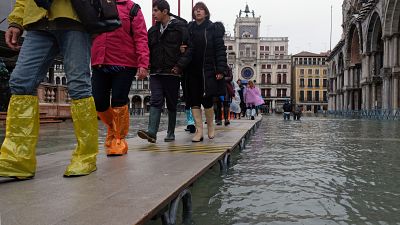 Tourists walk in St. Mark’s Square after days of severe flooding in Venice, Italy, November 17, 2019.