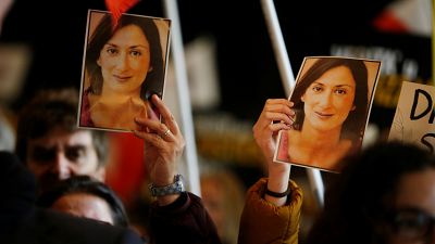 People carry photos of assassinated anti-corruption journalist Daphne Caruana Galizia during an anti-corruption protest against the government of Prime Minister Joseph Muscat,