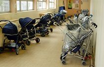 FILE PHOTO: Pushchairs are parked at the entrance of a day-nursery in Vincennes, near Paris, April 30, 2003.
